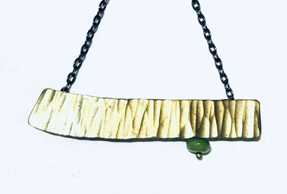 Brass stamped pendant with green accent