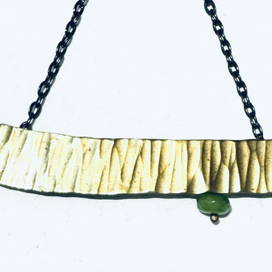 Brass stamped pendant with green accent